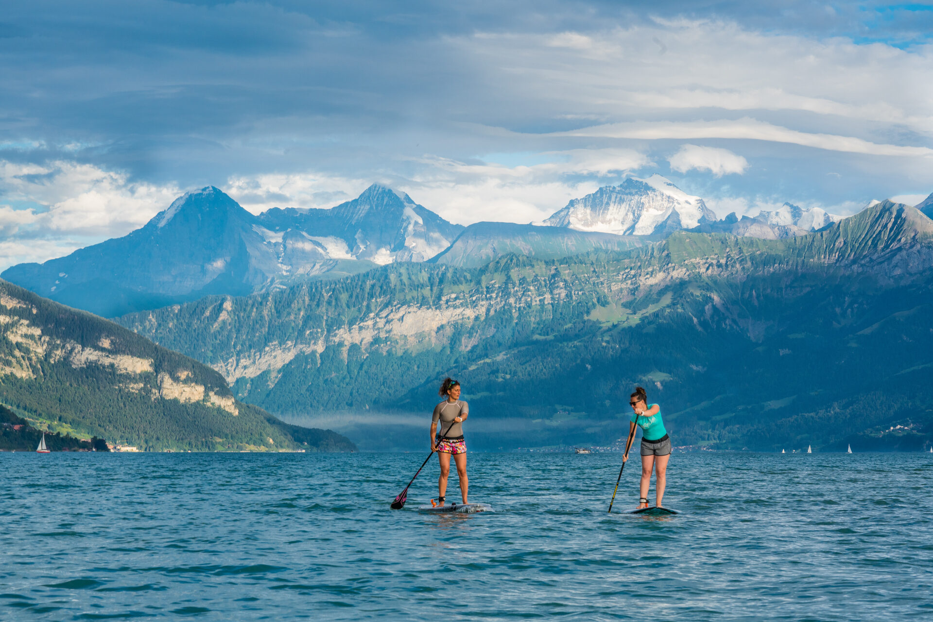 Zwei Standup Pladdlerinnen auf dem Thunersee vor Eiger, Mönch und Jungfrau